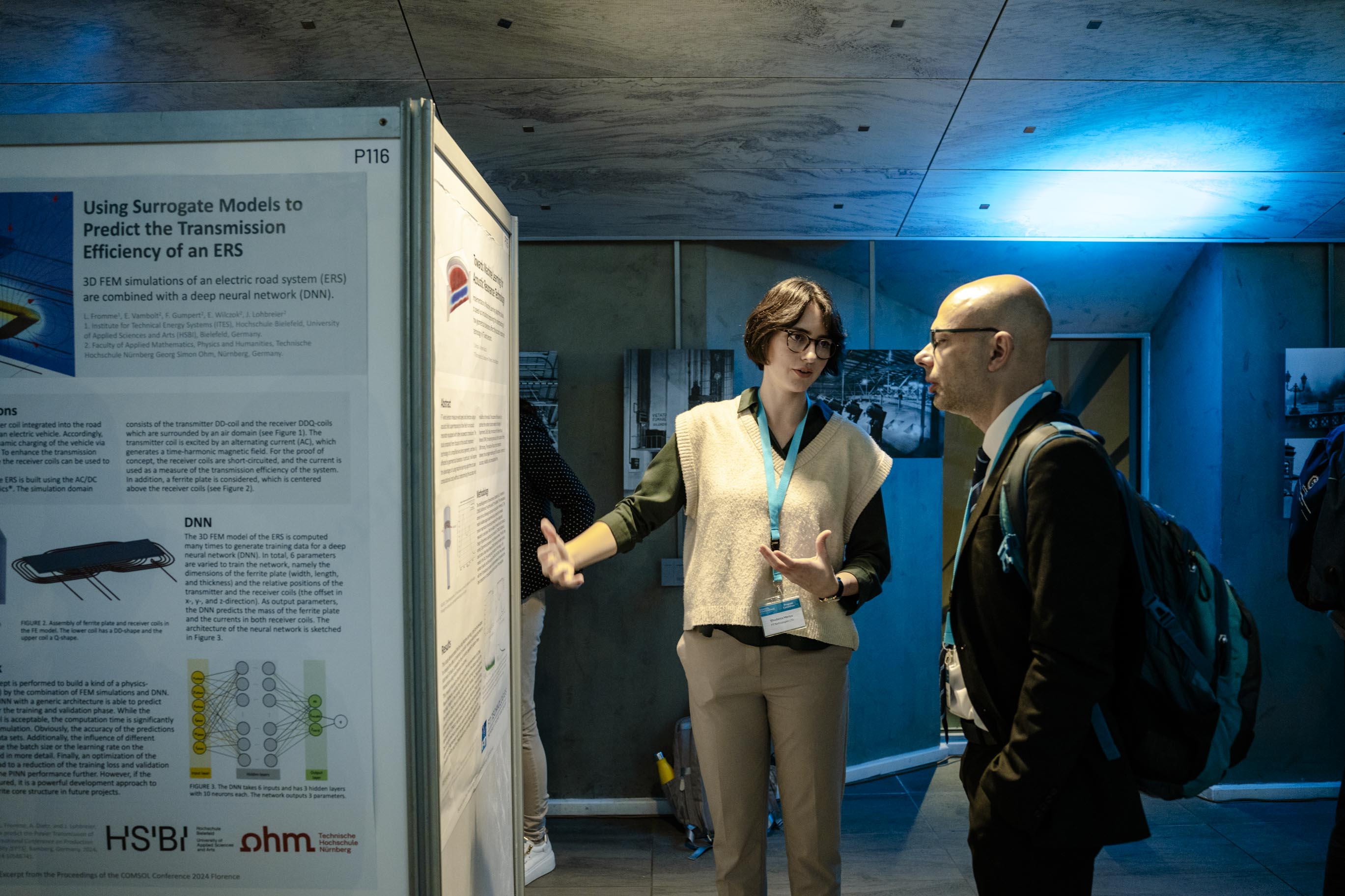 Conference attendees having a discussion in the poster hall.